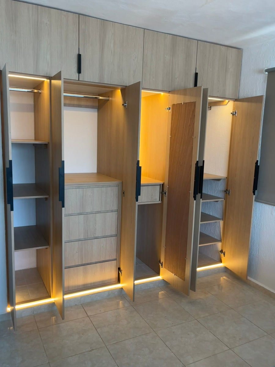 Closet a la medida de madera clara con luces LED, hecho por MelaminArt